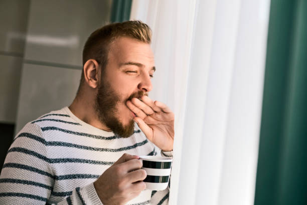 istock Young man drinking first morning cup of coffee 1197161279