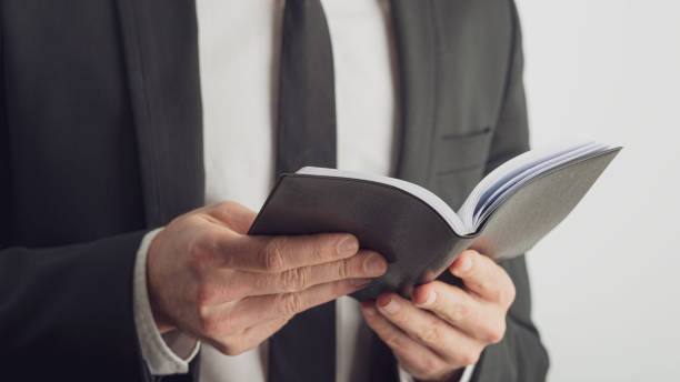 istock Businessman looking and reading from his black notebook 1197165791