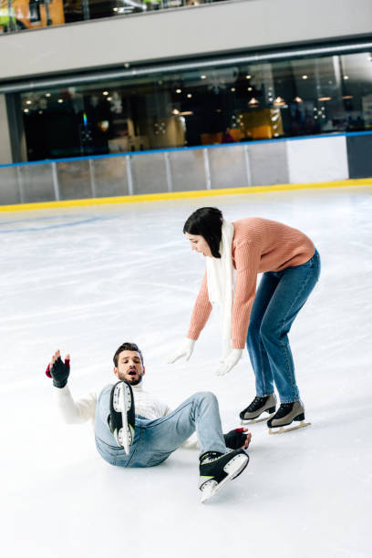 istock worried couple spending time on skating rink while man falling on rink 1197172471