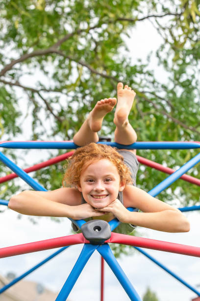 istock Girl Upside Down On Jungle Gym Smiling at Camera 1197172982