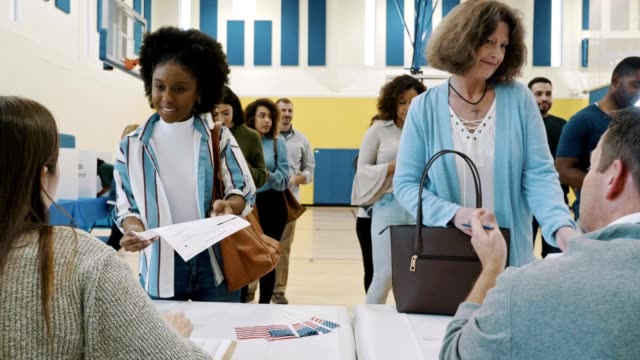 Group of voters receive ballots at polling place