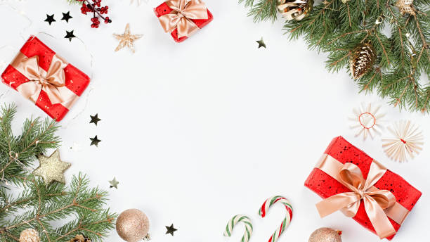 istock Christmas frame flat lay with pine, red presents, golden elements, candy canes, confetti. Christmas template on white background. Golden baubles, red gift boxes, pine. Christmas background, copy space 1197174576