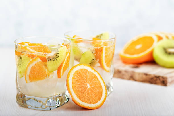 Summer refreshing non alcoholic cocktails with orange and kiwi fruits closeup still life. Summer mocktail with citrus and sparkling water, healthy lifestyle concept Summer refreshing non alcoholic cocktails with lemon, cucumber and mint, closeup soda water glass lemon stock pictures, royalty-free photos & images