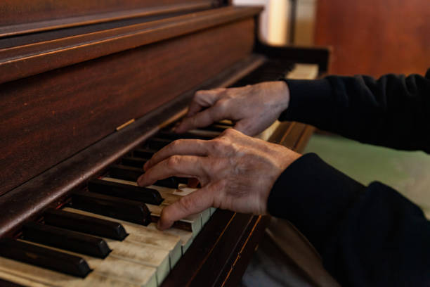 istock Elderly person plays music on piano. 1197178082