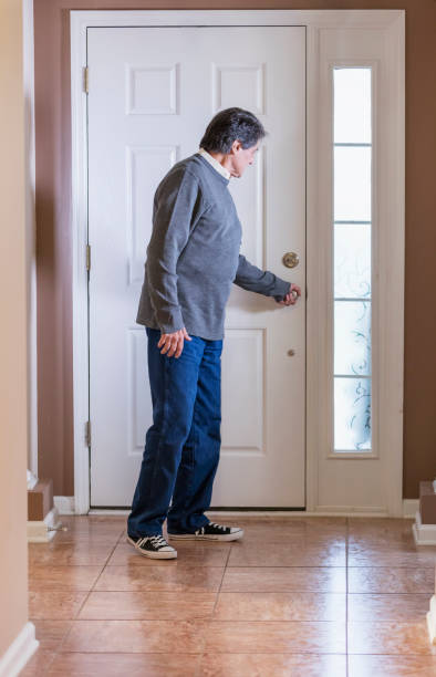 Senior Hispanic man opening front door