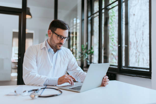 istock Doctor using laptop in medical office, portrait. 1197182186