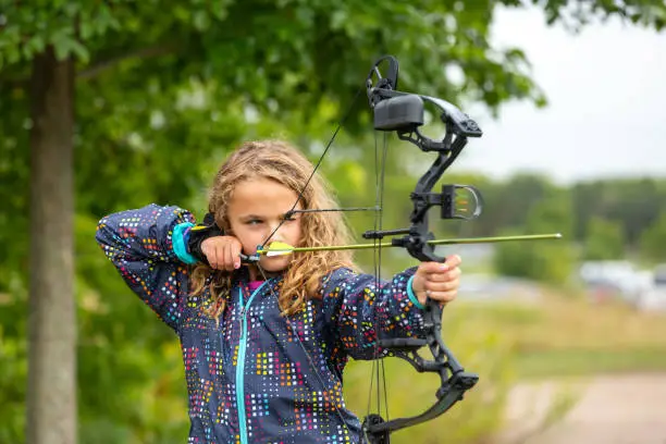 Photo of Young Girl Practicing Archery at Outdoor Range