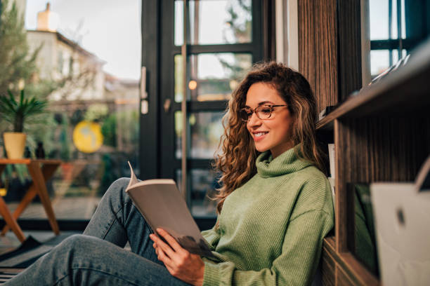 istock Cute girl relaxing while reading a book, portrait. 1197182232