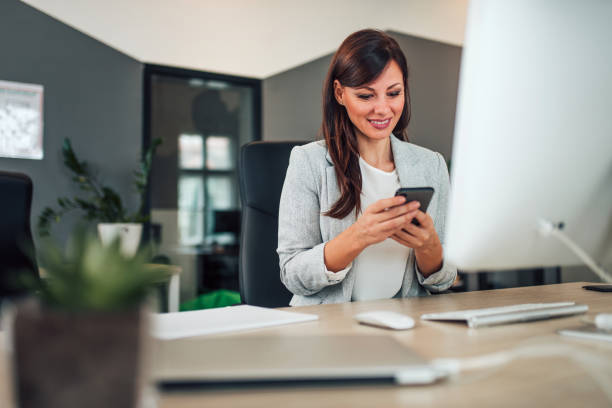 istock Businesswoman using smart phone in modern office, portrait. 1197182246