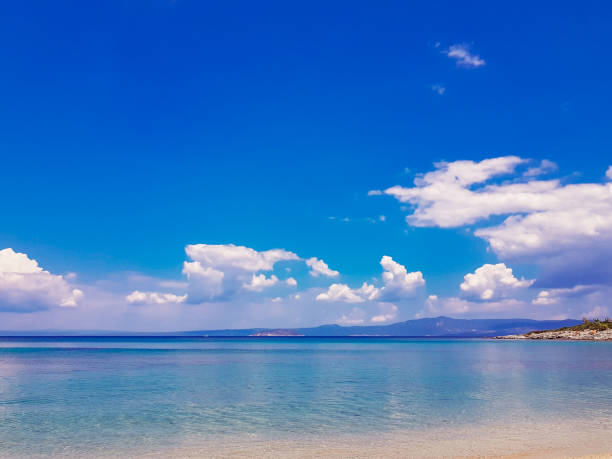 istock Seascape against the sky with white clouds and mountains. 1197182603