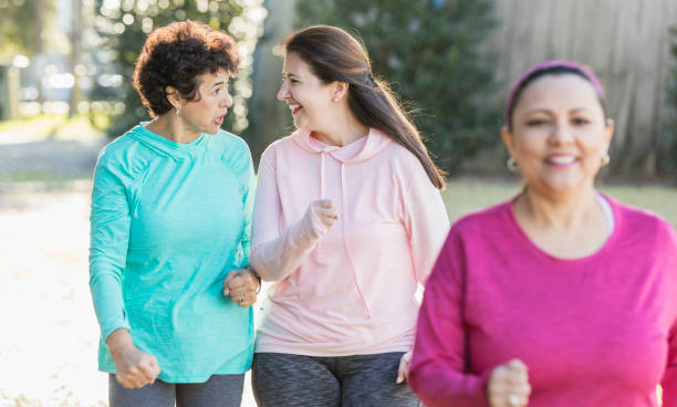 istock Two Hispanic women power walking in park 1197183265