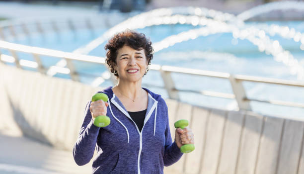 istock Senior Hispanic woman exercising with hand weights 1197183306
