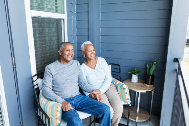 istock Senior couple relaxing on balcony, holding hands 1197184366