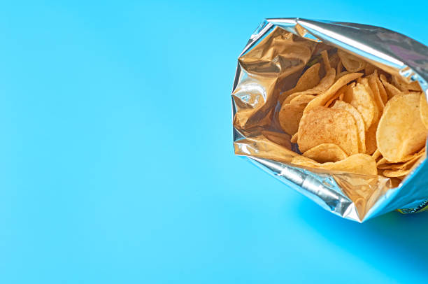 istock Single full shiny packaging of potato chips on blue background. Space for text 1197184591