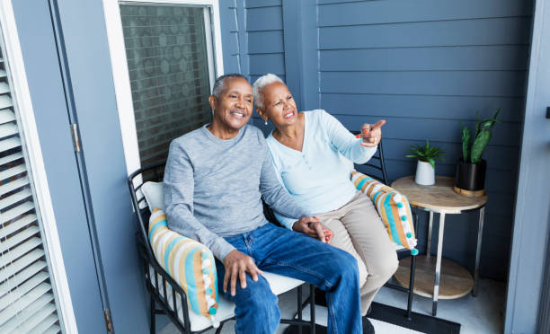 istock Senior couple relaxing on balcony, holding hands 1197184595