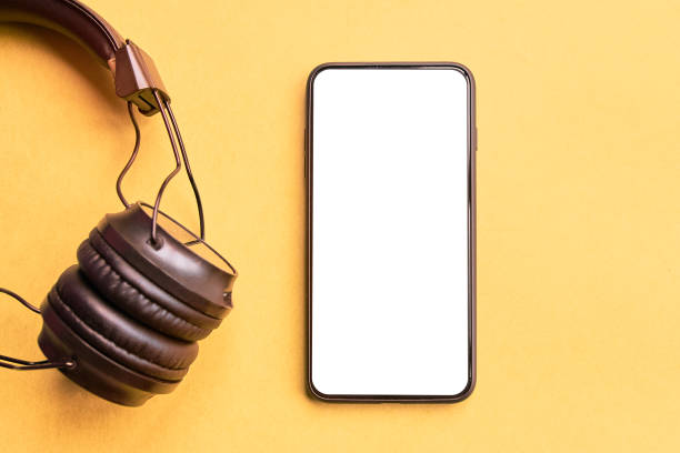 Headphones and smartphone Wireless Headphones and smartphone on colorful background. Isolated Phone and earphones for music sound on yellow background. kyrgyzstan photos stock pictures, royalty-free photos & images