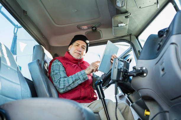 istock Senior Hispanic man driving semi-truck, using tablet 1197185655