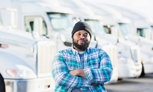 Hombre afroamericano con flota de semi-camiones photo