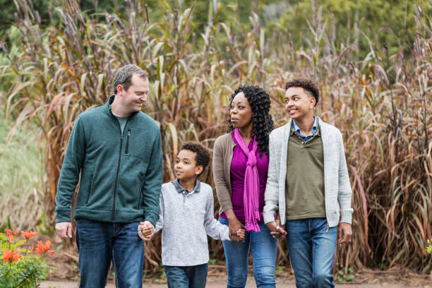 istock Interracial family with two boys walking in park 1197187973