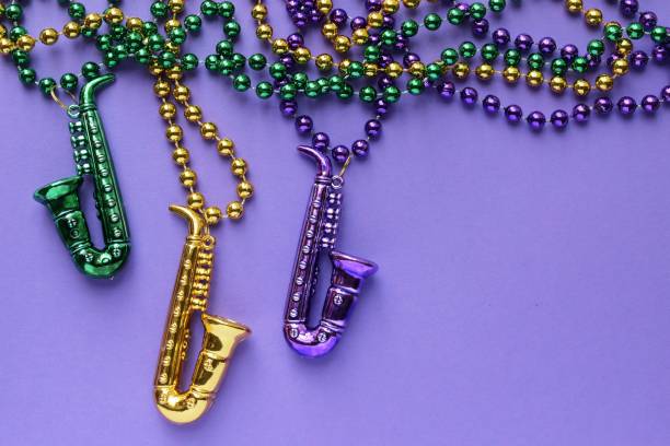 Mardi Gras beads Mardi Gras beads on a purple background new orleans mardi gras stock pictures, royalty-free photos & images