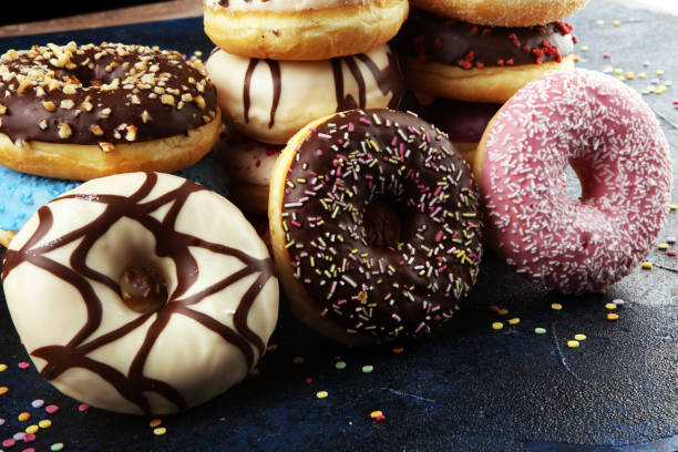 istock assorted donuts with chocolate frosted, pink glazed and sprinkles donuts 1197192899