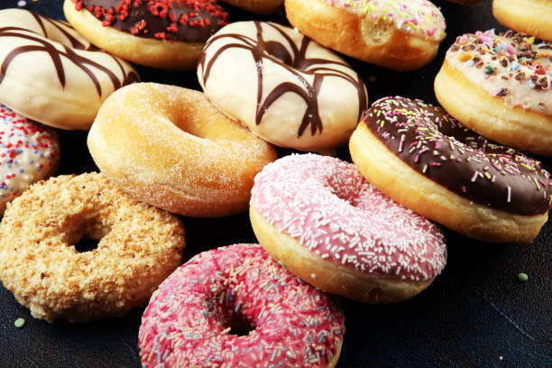 istock assorted donuts with chocolate frosted, pink glazed and sprinkles donuts 1197192946