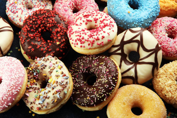 istock assorted donuts with chocolate frosted, pink glazed and sprinkles donuts 1197193044