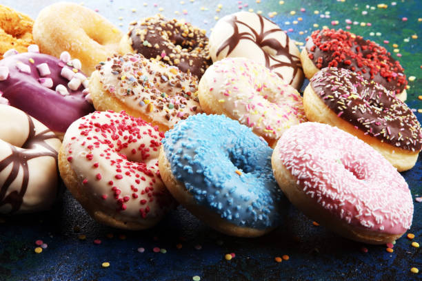 istock assorted donuts with chocolate frosted, pink glazed and sprinkles donuts 1197193636