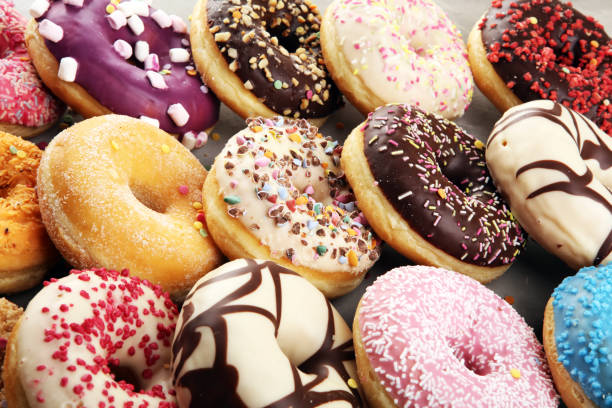 istock assorted donuts with chocolate frosted, pink glazed and sprinkles donuts 1197193762