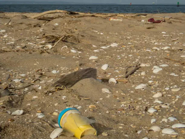 Plastic debris bottlecaps styrofoam garbage on beach on a sunny winter day at Sandy Hook, NJ