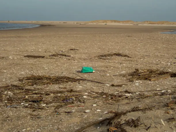 Plastic debris bottlecaps styrofoam garbage on beach on a sunny winter day at Sandy Hook, NJ