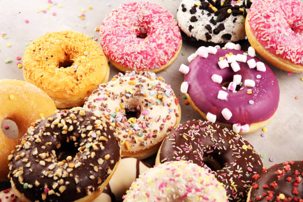 istock assorted donuts with chocolate frosted, pink glazed and sprinkles donuts 1197194693