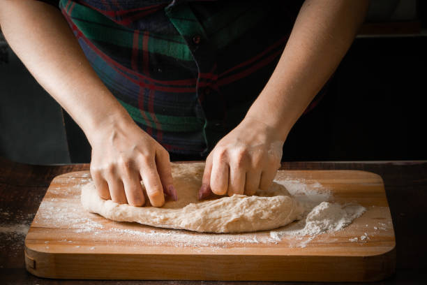 istock Kneading the dough on a wooden board on a dark background 1197194726