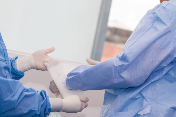 istock Nurse helping the surgeon to put on sterile gloves before surgery 1197199042