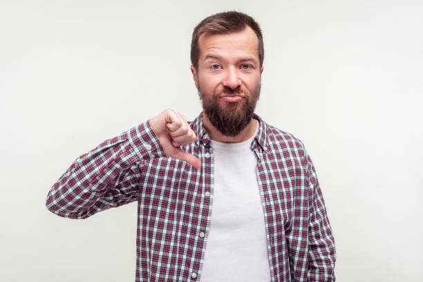 istock Dislike! Portrait of upset disappointed bearded man showing thumbs down, disapproving solution. white background 1197203988