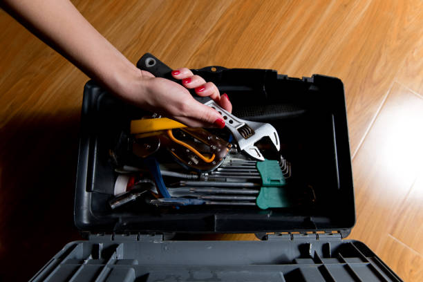 istock girl with red manicure takes an adjustable wrench from a tool box 1197204076
