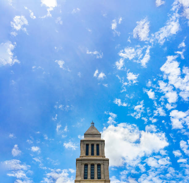 George Washington Masonic National Memorial tower over a blue cloudscape sky.
