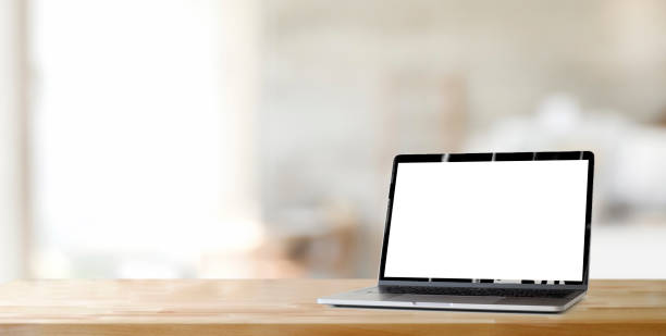 istock Cropped shot of open blank screen laptop computer on wooden table and copy space with blurred office 1197212192