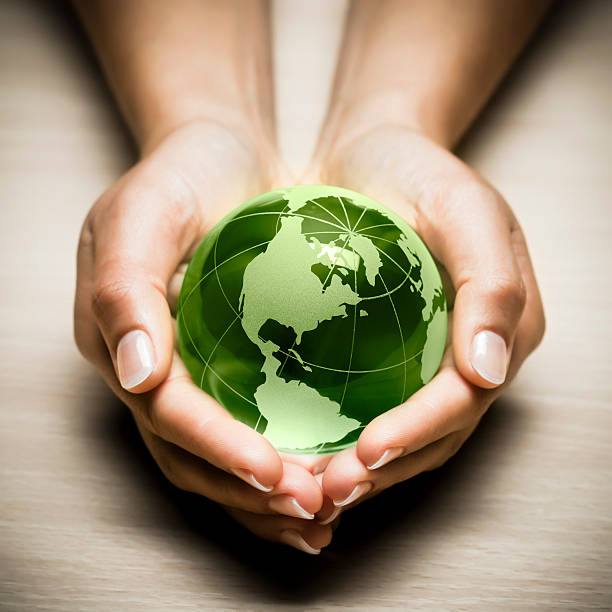 istock Green glass globe being held in hands 119721272