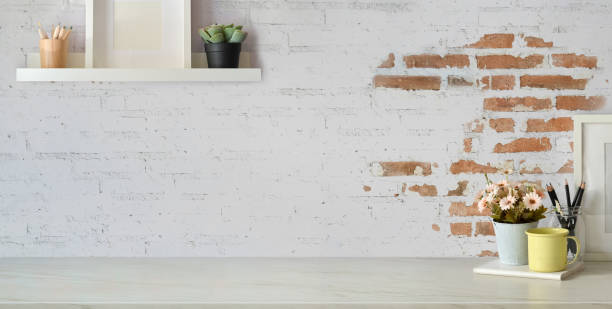 istock Modern stylish workplace with office supplies and copy space on white table and grey plank wall 1197212743