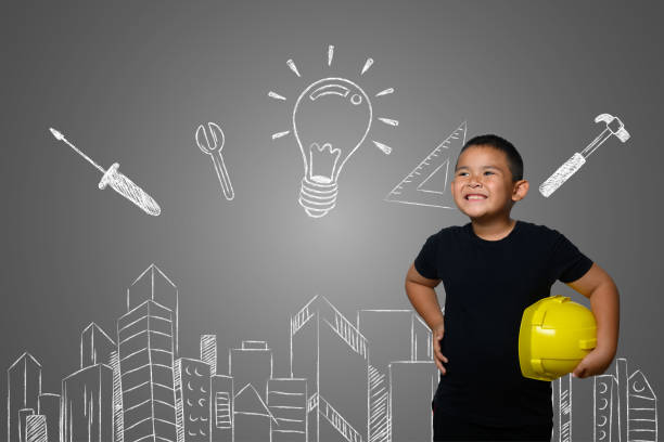 istock A boy wearing a yellow engineer hat and a house plan on a blackboard 1197220555