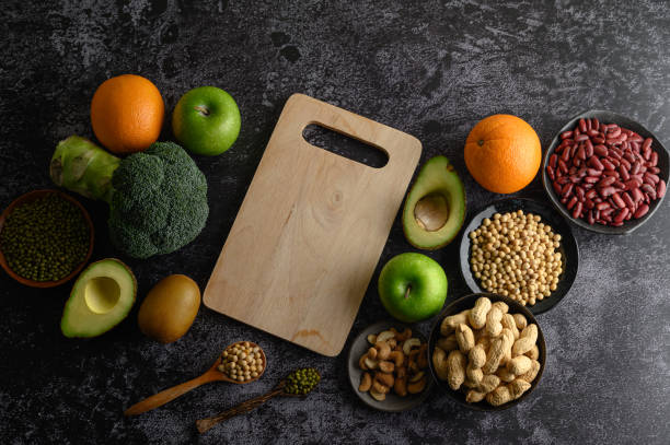 istock legumes and fruit on a black cement floor background. 1197222543