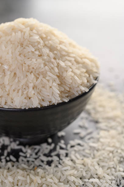 istock Milled rice in a black bowl on the black cement floor. Selective focus 1197223189