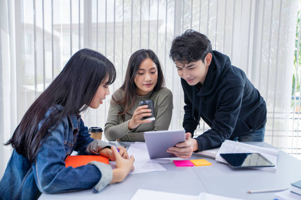 Group Students Smile and have fun and using tablet It also helps to share ideas in the work and project. And also review the book before the exam