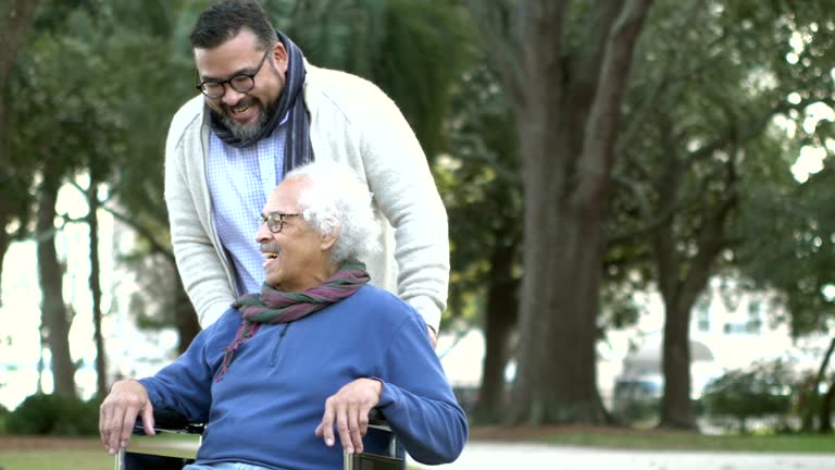 Senior Hispanic man in wheelchair, with adult son