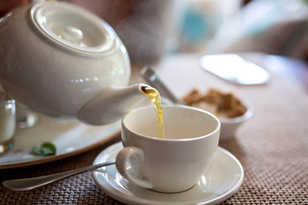 istock Pouring tea from their porcelain teapot. 1197235120