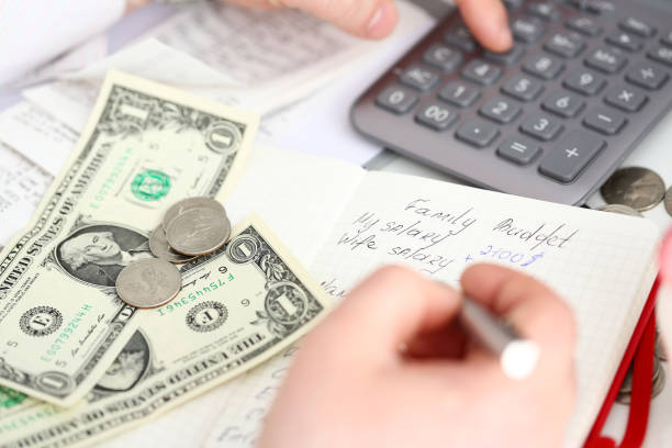 istock Male arm making notes in red notepad about family budget evaluating expenses 1197240366
