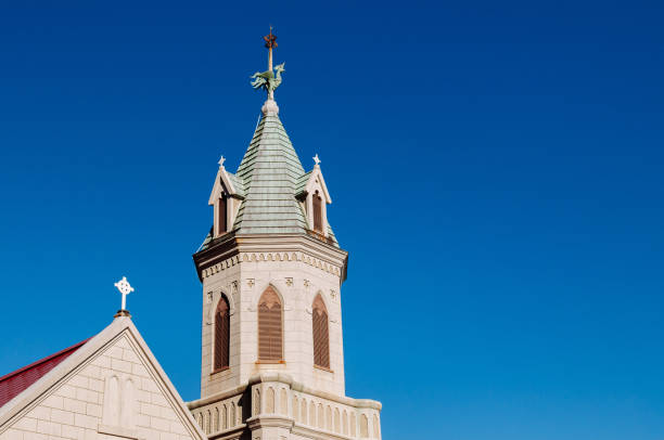 campanile della chiesa cattolica di hakodate contro il cielo invernale blu - cross autumn sky beauty in nature foto e immagini stock
