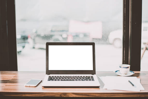 Mockup image of laptop with blank white screen on wooden table of In the coffee shop. Mockup image of laptop with blank white screen on wooden table of In the coffee shop. raincoat stock pictures, royalty-free photos & images