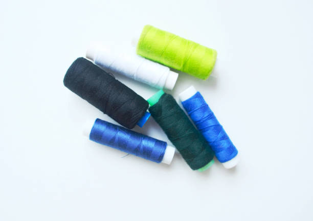 A set of multi-colored sewing threads on a white isolated background.
